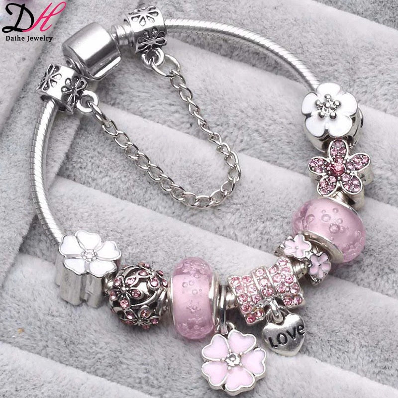 La Maricell silver charm bracelet with white flower and crystal charms.
